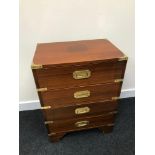 A Reproduction campaign chest of drawers. Fitted with brass fitments. Measures 61.5X46X30 cm