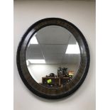 Antique oval bevel edge mirror. Fitted in a wooden frame. Measures 61x51cm