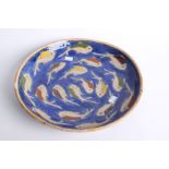 A Far Eastern ceramic charger decorated with fish, brassware, a Japanese fan with topographical