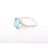 A 1950’s blue zircon and diamond ring, centred with a rectangular blue zircon, between graduated