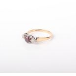 A 9ct gold, garnet and diamond ring, the central garnet flanked by two diamonds, 2.6g in total