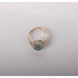 A 9ct gold emerald and diamond oval cluster ring, London 1996 in a modern Staffordshire type emerald