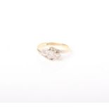 A diamond three stone cross-over ring, the graduated round brilliants illusion set in white on a