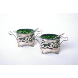 A pair of Art Nouveau silver oval salt cellars, each with pierced sinuous scroll sides and handles