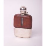A clear glass hip flask with leather mounts and a plated hinged screw cover and removable cup, 14.