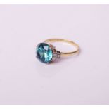 An early 20th century gold, blue zircon and diamond dress ring, centred with a large blue zircon