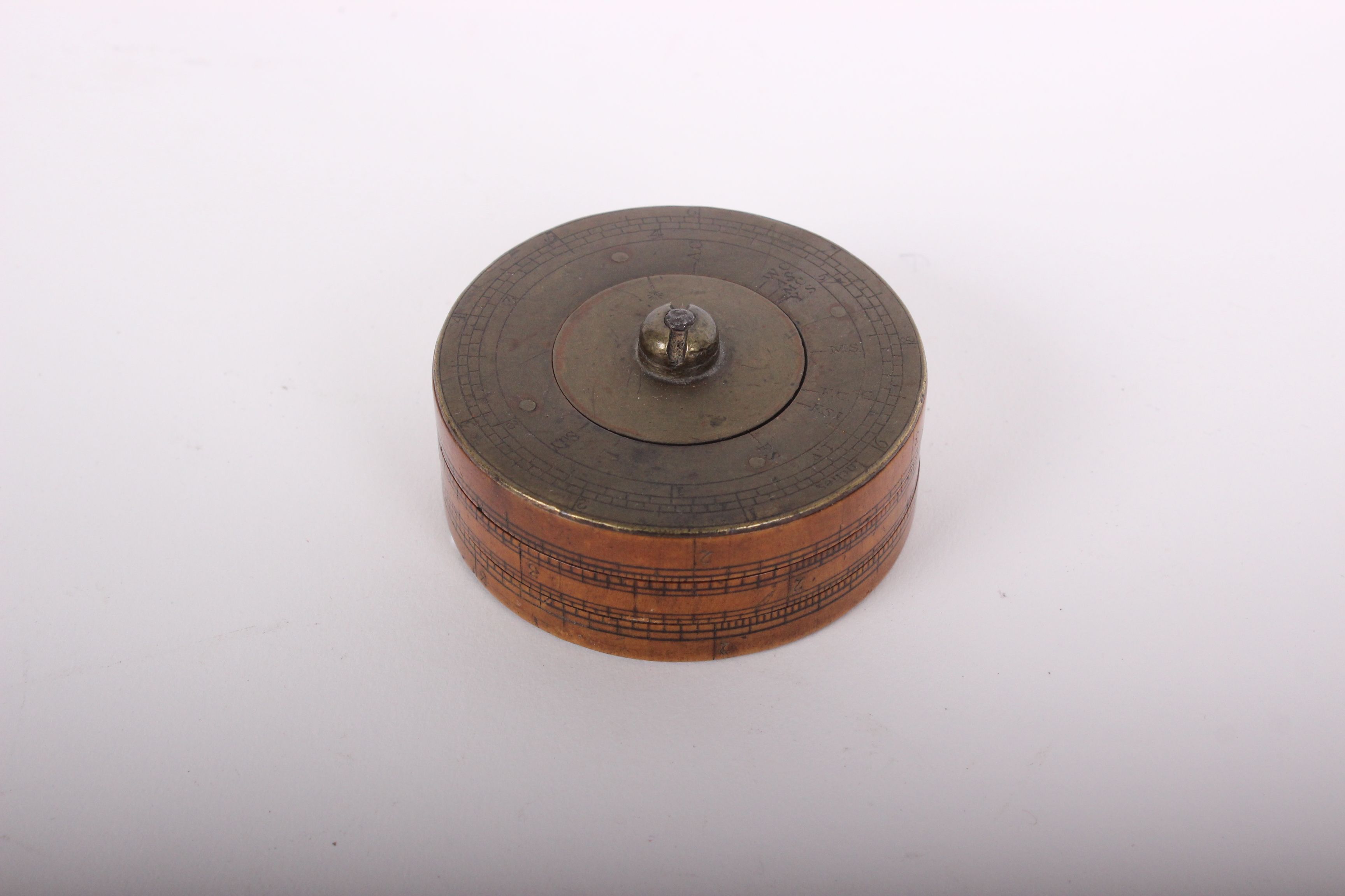 A late 18th century brass and boxwood cylindrical calculator, the top section rotating with three