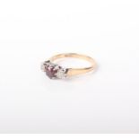 A 9ct gold, garnet and diamond ring, size O. The central round garnet flanked by two diamonds, 2.