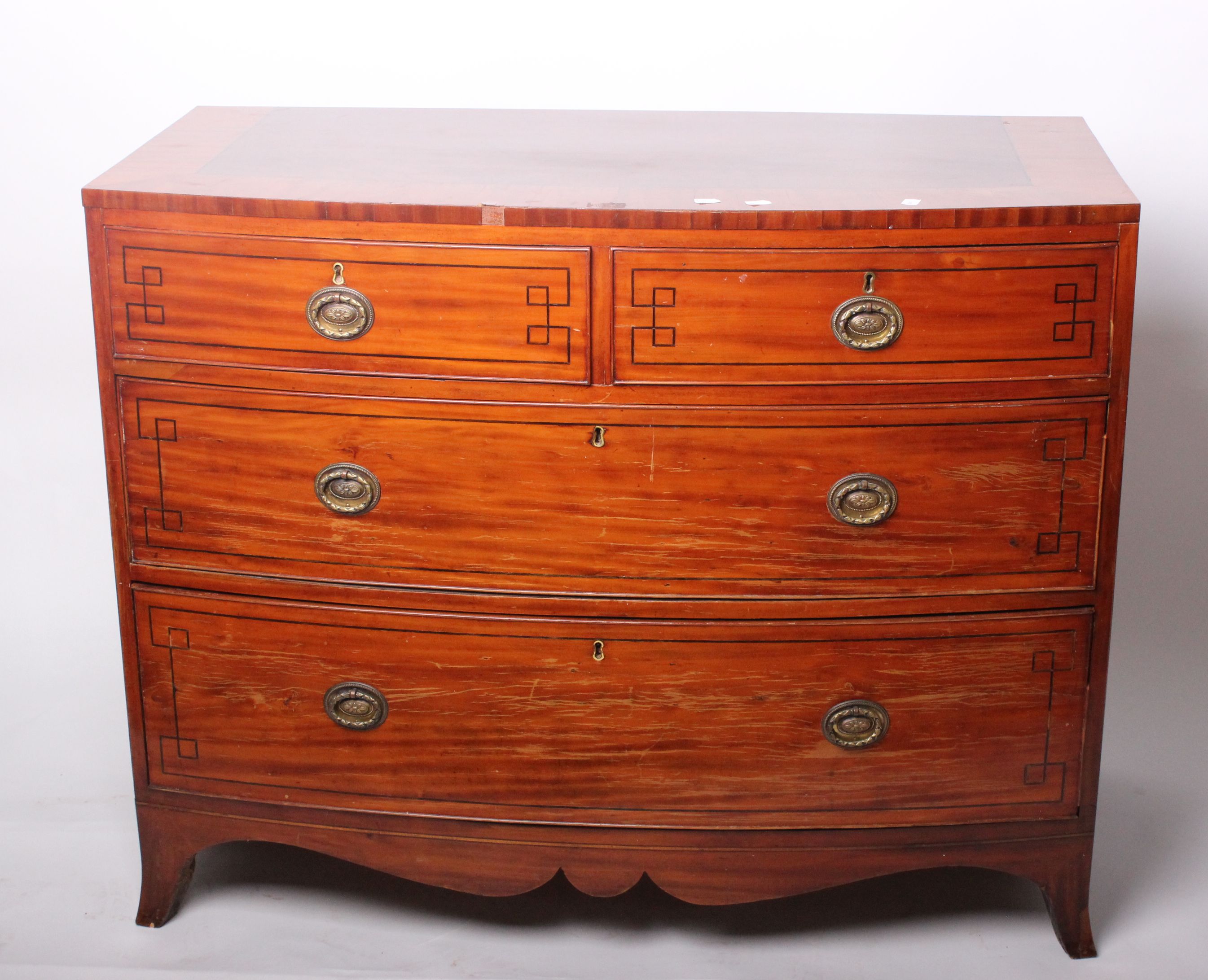 An early 19th century inlaid mahogany bowfront chest with two short and two long drawers, with a