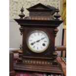 A late Victorian mantel clock in carved walnut case with two train gong striking movement,