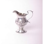 An early George III silver pear-shaped cream jug, with gadrooned borders, a leaf-capped double