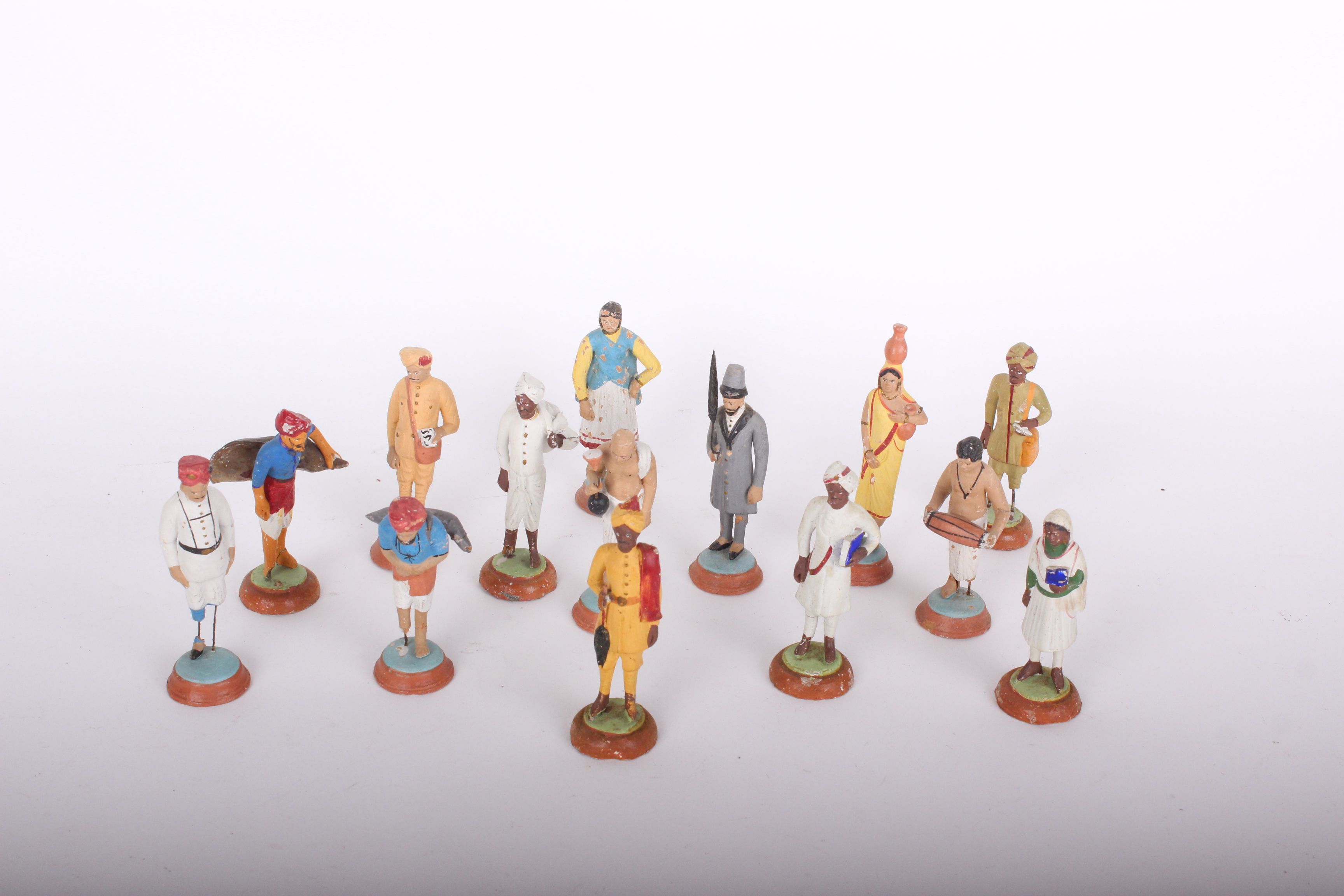 A collection of twenty four painted plaster figurines: Indian costume based on terracotta 19th