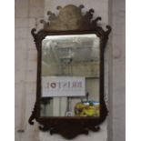 A George III wall mirror with figured walnut frame with scroll cut cresting and pendant panels