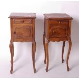 A matched pair of French late 19th Century bedside cupboards each with variegated marble top, frieze