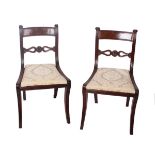 A pair of Regency mahogany side chairs with drop-in seats on sabre legs