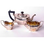 A silver three piece shaped-oblong tea service, each with concave-fluted corners and angular