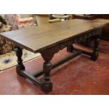 An oak refectory table with plank top and cleated ends, carved frieze on turned baluster legs joined