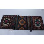 An early 20th Century double-sided carpet and flatweave Baluch saddle bag face; 125 cms x 36 cms;