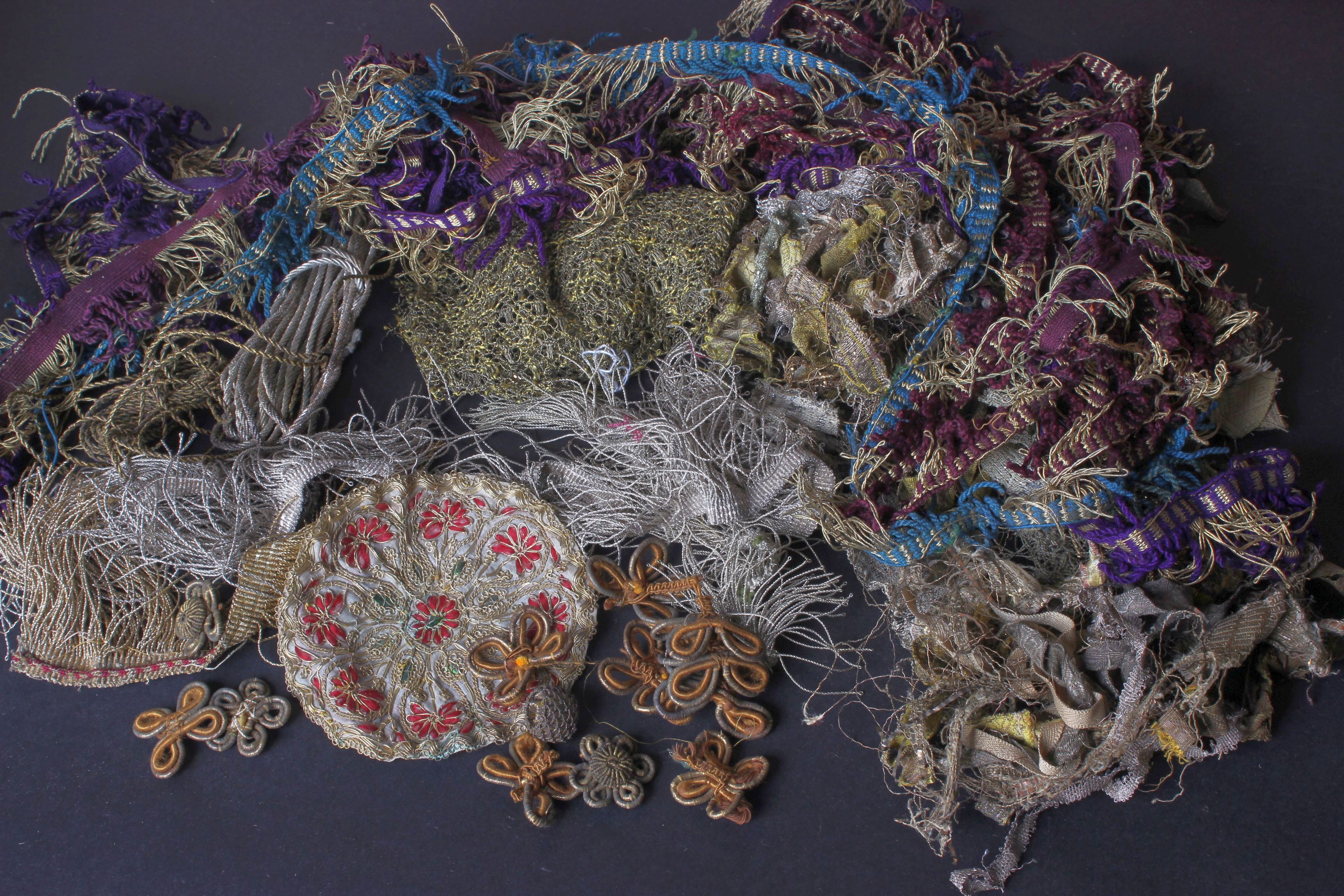 A collection of late 19th and early 20th Century metallic and wool trimmings, fringing and