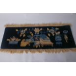 An early 20th Century Baotou Chinese fringed woollen rug; having a brown, cream and blue still-