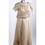 An early 20th Century cream two-piece costume embellished with silver sequins; a late 1940s ivory