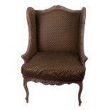 A French style wing back armchair with limed oak frame and a pouffe