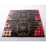 A lacquer chess/backgammon board, hinged and linked as four pieces, open 42.5cm square, a box of