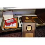 A collection of presentation panels and plaques including six 'Champions Club' gilt metal medals (