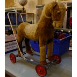 A 20th century push along toy: a donkey, straw stuffed on a metal stand part restored, h.63cm