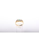 An emerald and diamond three stone ring, the rectangular head centred with a round mixed-cut emerald