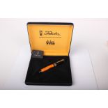 Pens: a Delta Dolcevita medium fountain pen, orange with black cap and 18ct nib (length 11.5cm)