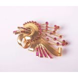 A 1940's style gold and synthetic-ruby odeonesque brooch in the form of scrolls, arches and stems,