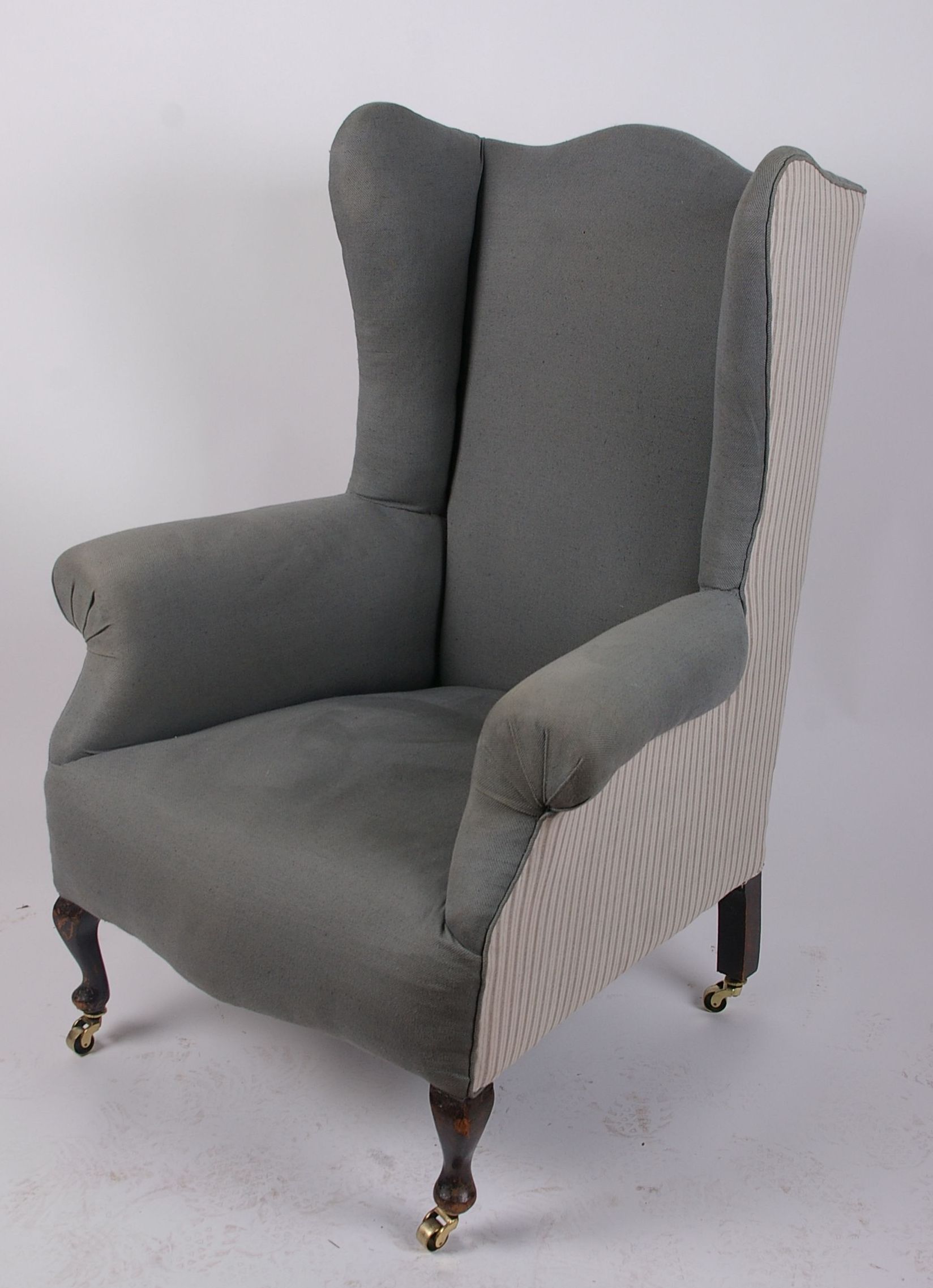 A George III style wing armchair with brass castors 85cm wide