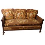 An early 20th century mahogany framed double caned three piece bergere suite, sofa 160cm length