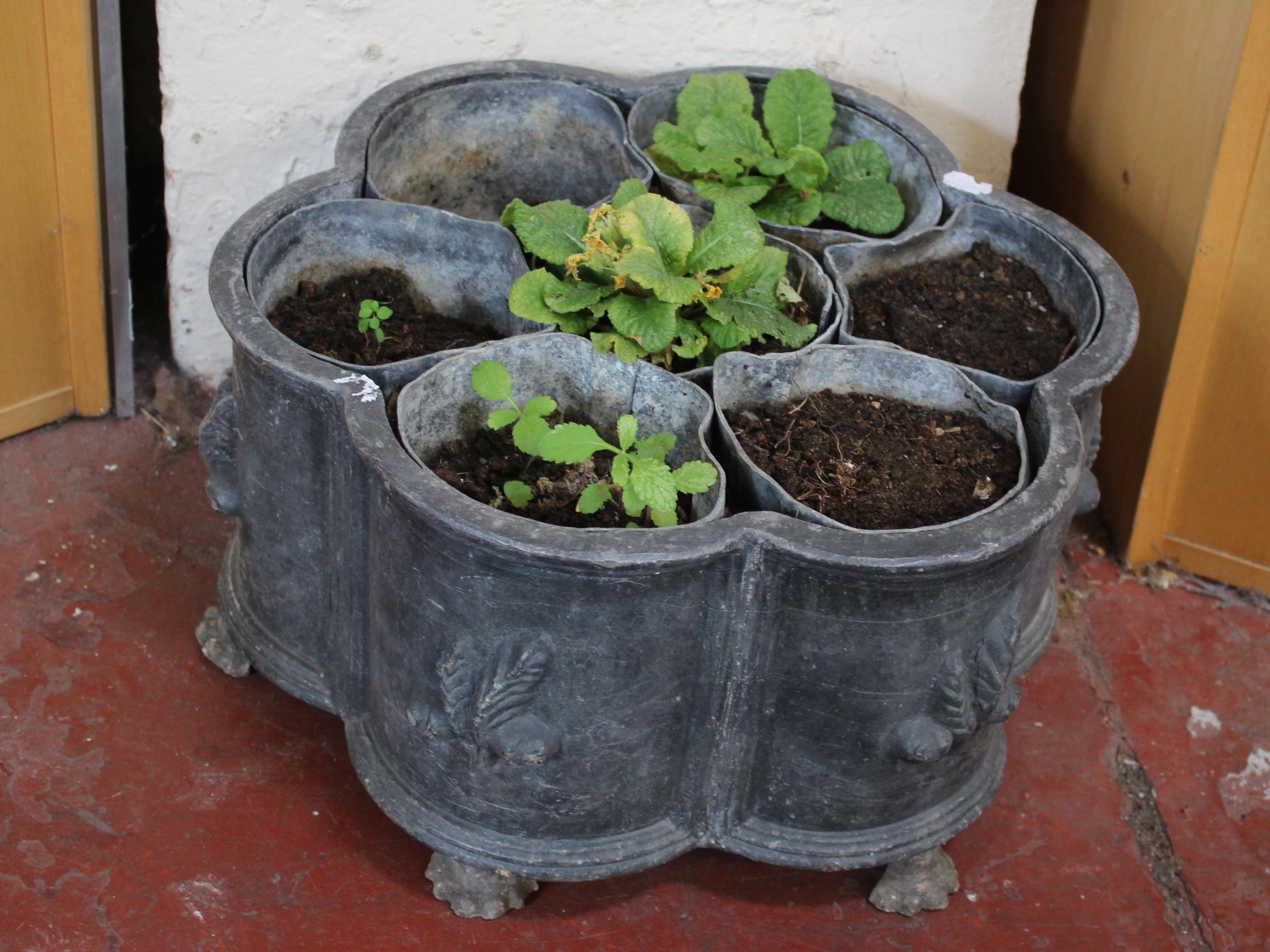 A Georgian style lead planter of sectional form, with six individual compartments on paw feet