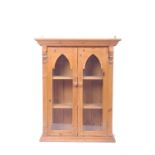 A waxed pine wall cabinet with gothic arch glazed doors 75 cm wide 93cm high