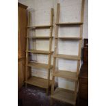 A graduated pair of modern waterfall ladder shelves in beech finish, both 103cm high, 50cm and