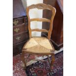 A matched set of eight French oak carved ladder back dining chairs each with rush seat