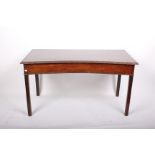 A George III mahogany inverted bow fronted serving table with carved top edge and square chamfered