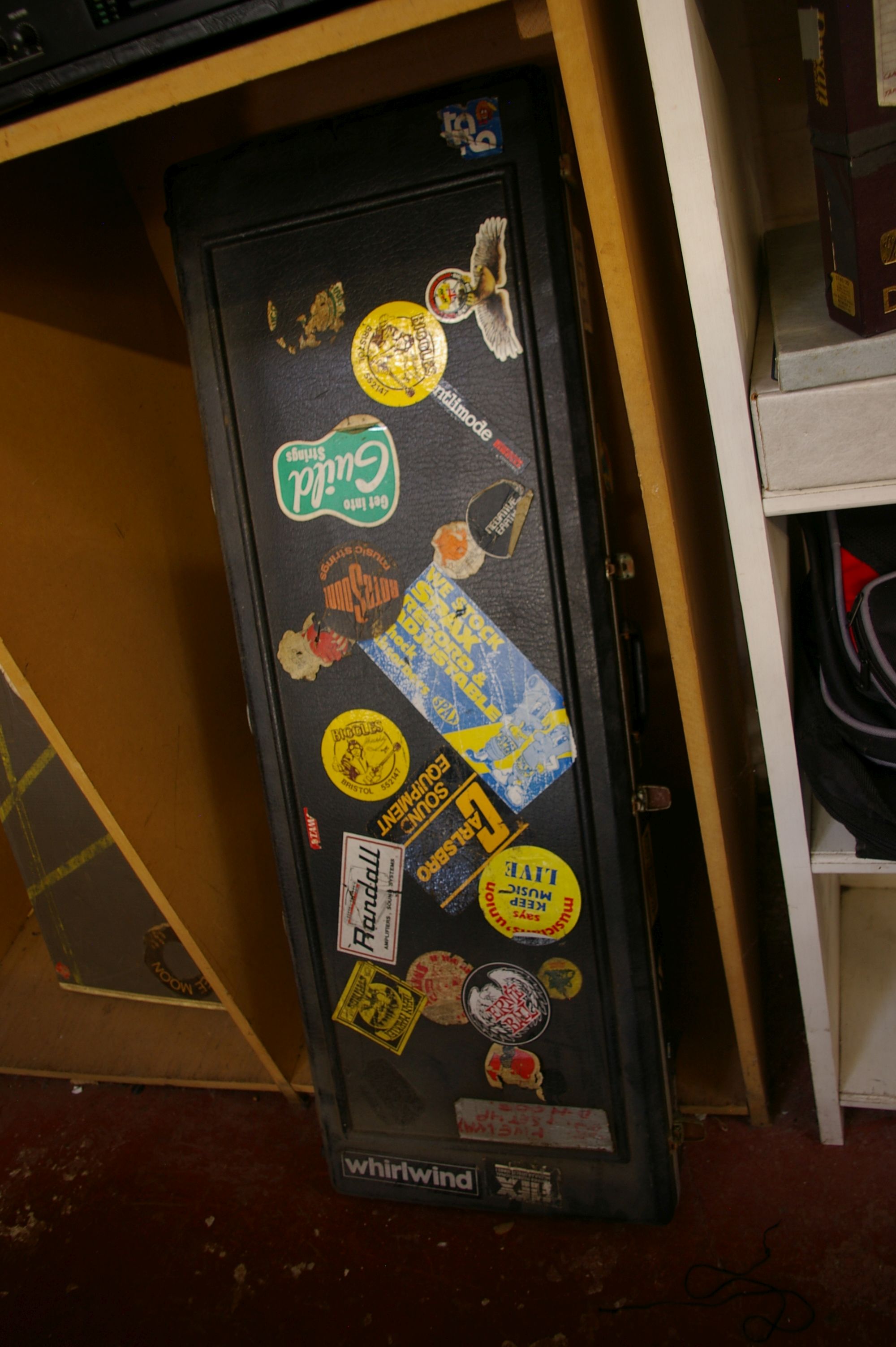 A much-used hard guitar case and several as new soft guitar cases.Provenance: from the estate of