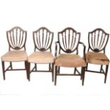A set of four George III mahogany dining chairs, to include one armchair