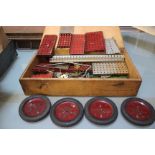 A wooden box containing Meccano pieces: four wheels, pulleys, wheels, etc, circa 1950's
