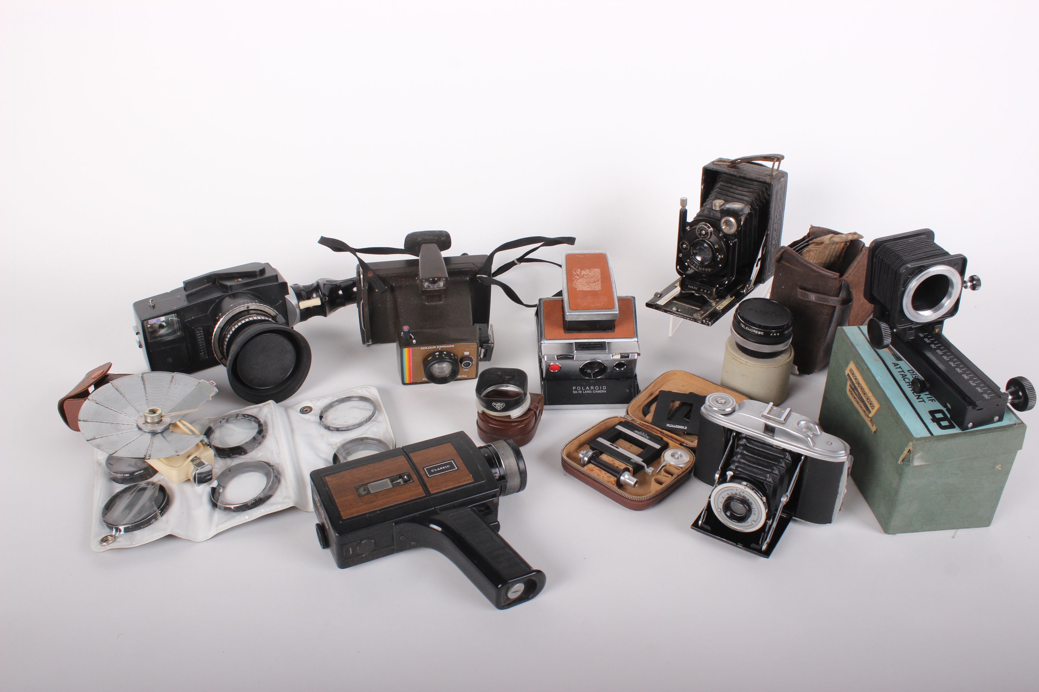 Cameras: a collection including Tenax Compur with case and plates, a Polaroid SX-70 land camera,