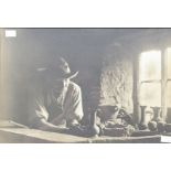 A pair of early 20th Century black and white framed photographs depicting a potter at work, possibly