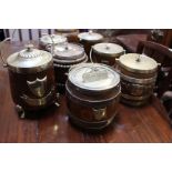 A collection of eight early 20th century oak biscuit barrels with silver plated mounts and ceramic