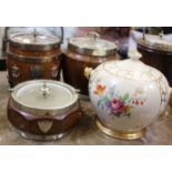 A collection of seven early 20th century oak biscuit barrels with silver plated mounts and ceramic