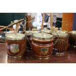 A collection of eight early 20th century oak biscuit barrels with silver plated mounts and ceramic