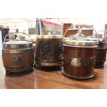 A collection of six early 20th century oak biscuit barrels with silver plated mounts and ceramic