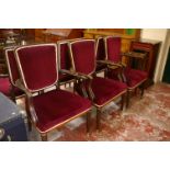 A set of six French armchairs with red velvet upholstery and brass feet.