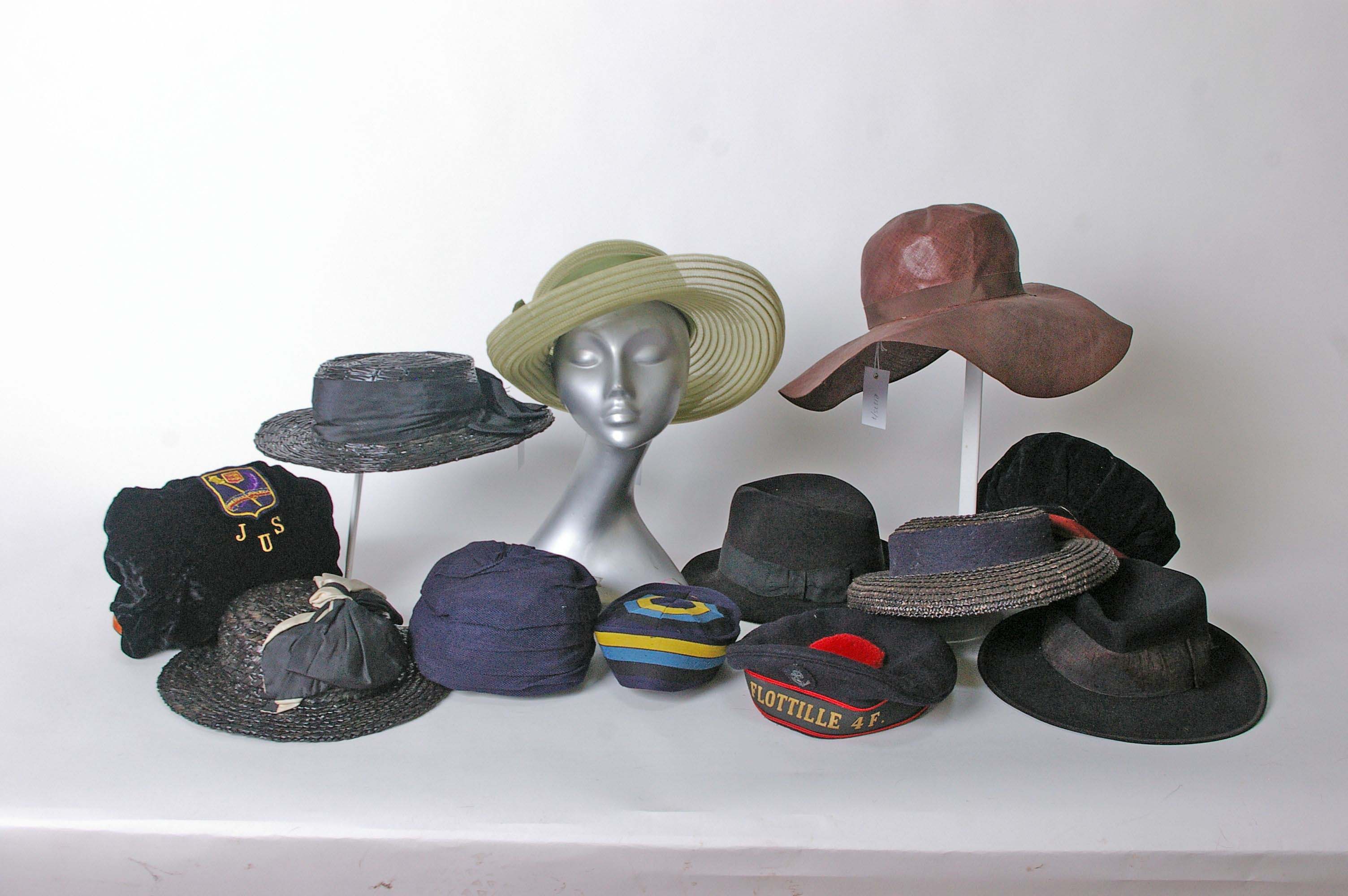 A 1930s fine weave brown straw hat with a wide brim; three black straw and raffia hats with ribbon